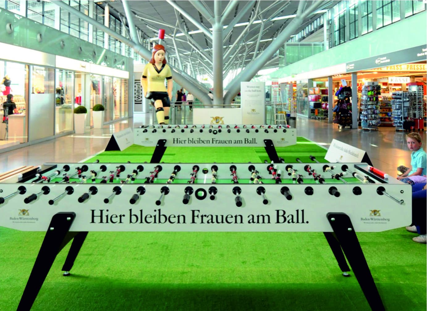 Ein Tischkicker in einem modernen Einkaufszentrum mit dem Slogan "Hier bleiben Frauen am Ball".